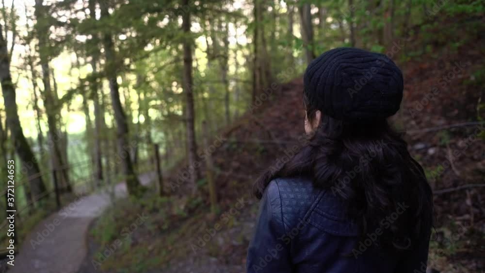 Back View Of A Young Girl Walking And Enjoying The View Of The Natural Forest In Lauterbrunnen, Switzerland. - trucking shot Back View Of A Young Girl Walking And Enjoying The View Of The Natural Forest In Lauterbrunnen, Switzerland. - trucking shot