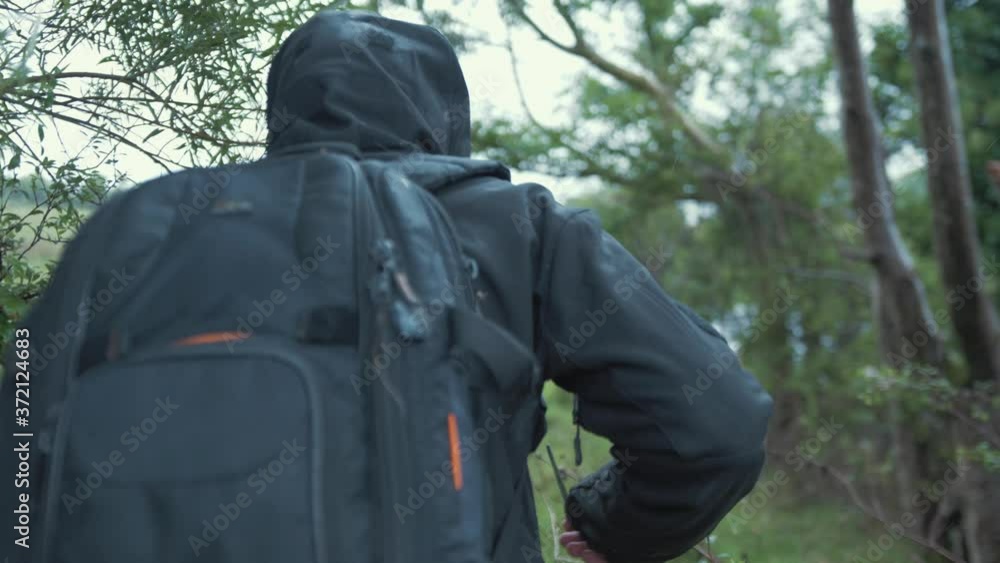 Young refugee jumps fence crossing border wearing backpack Young refugee jumps fence crossing border wearing backpack
