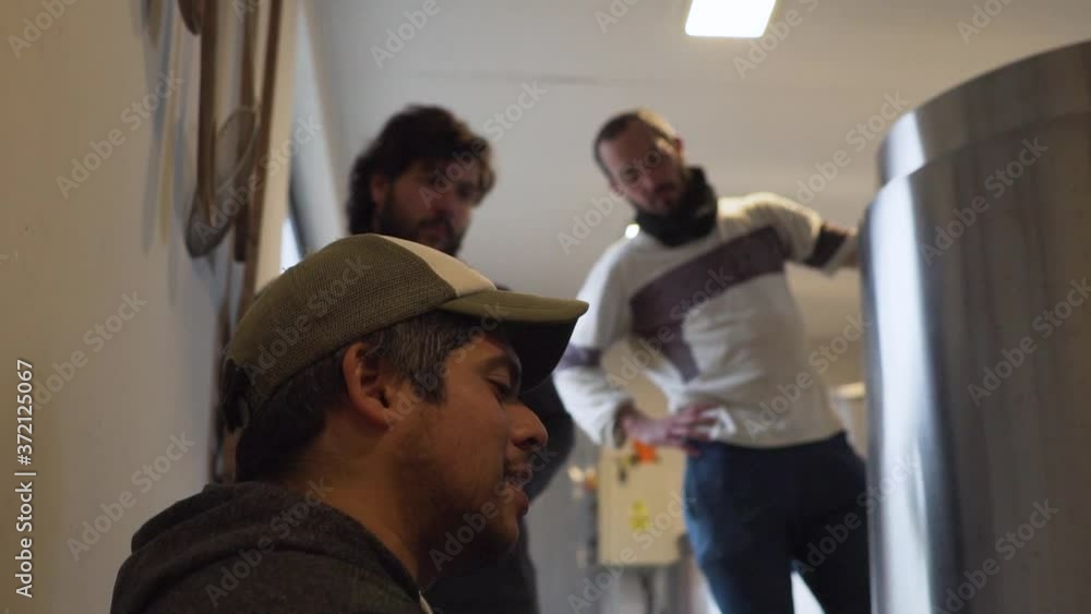 Brewers Having A Conversation While Brewing Beer In The Brewery - selective focus slowmo Brewers Having A Conversation While Brewing Beer In The Brewery - selective focus slowmo