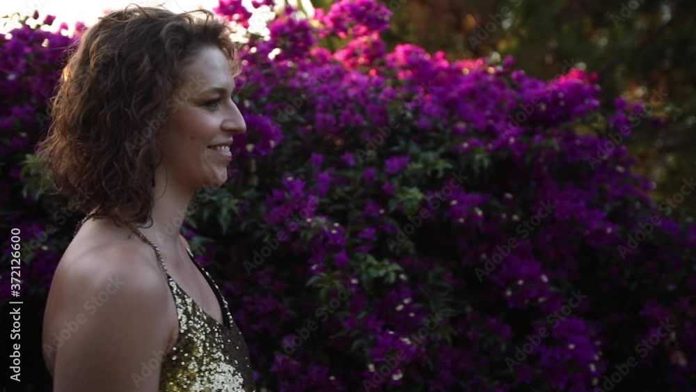 Girl playful having fun, making a joke, laughing, purple flowers, bougainvillea Girl playful having fun, making a joke, laughing, purple flowers, bougainvillea