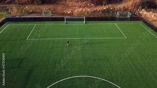 Female soccer player shoots for goal and wins. Moving drone shot from above. photo