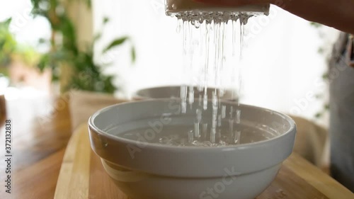 Young Woman washing and filtering Cashews photo