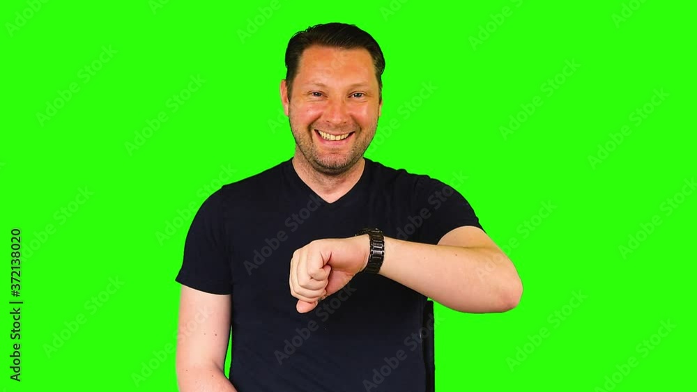 Green screen, man looking at his watch and being happy Green screen, man looking at his watch and being happy