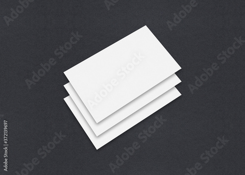 Blank white Business card mockup stacks on grey textured paper background.