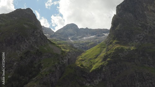 Extreme zoom in from the complete mountain range to the last sunny valley of the mountain back . 4K ProRes photo