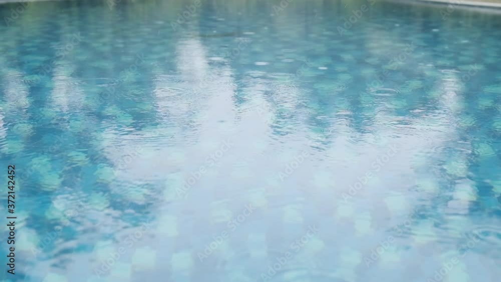 Raindrops falling on the surface of a swimming pool slow motion Raindrops falling on the surface of a swimming pool slow motion