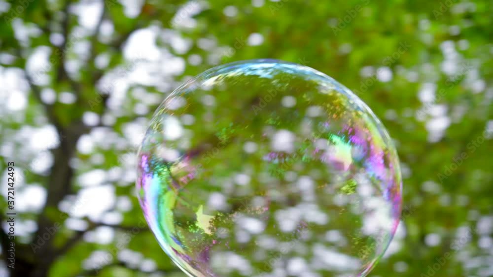 Big soap bubble flying around and popped by a happy child, jumping in the air Big soap bubble flying around and popped by a happy child, jumping in the air