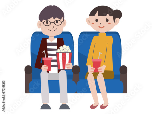 映画館で映画を見るカップル