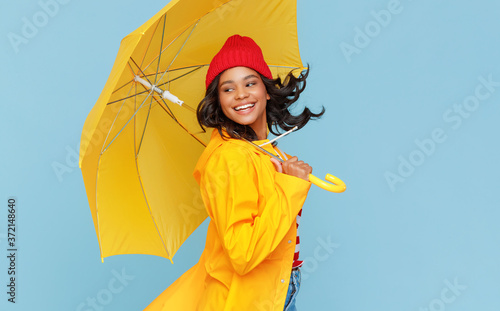 Happy ethnic female dancing under rain.