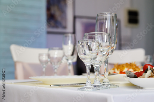 Glass goblets and wine glasses next to a white plate on the banquet table