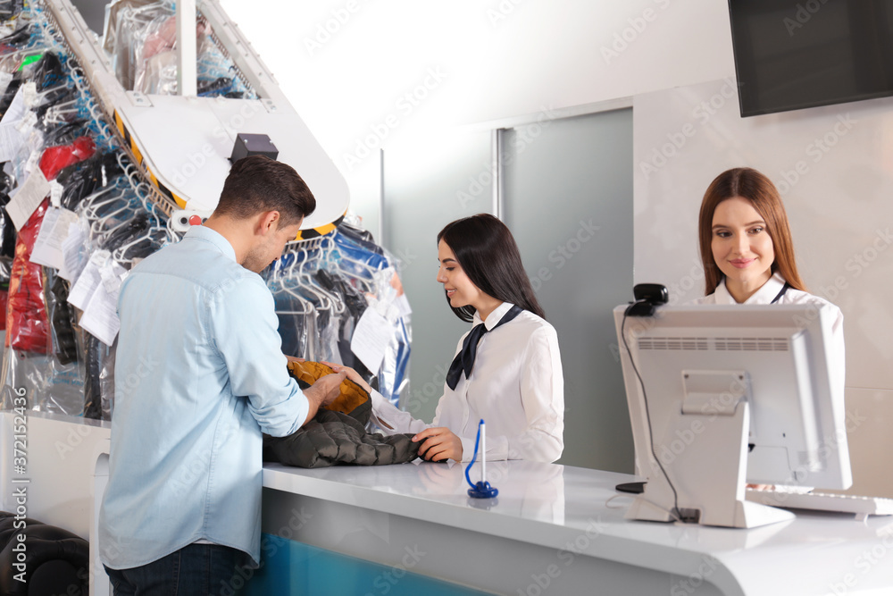 Fototapeta premium Female employees working with client at dry-cleaner's