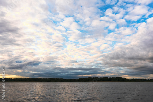 Blue sky with dark clouds over a lake in the Smolensk region, Russia