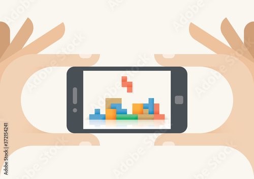 Gamer hands holding mobile smartphone with video game on screen. Concepts: Cybersport, championships, online gaming industry, old arcade games (Tetris etc.)