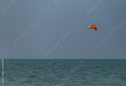A surfboard is surfing on the sea near the long bridge in Pattaya beach of eastern in Thailand on a long holiday.