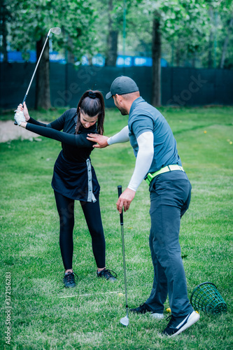 Individual golf lesson. Young woman having a golf lesson with golf instructor