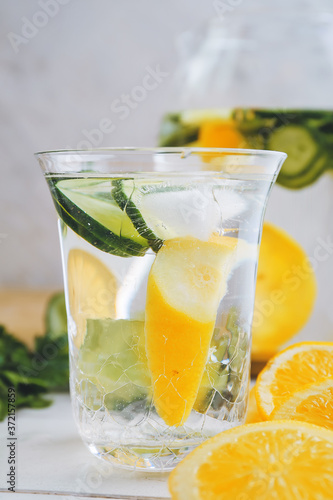 Glass of fresh lemonade with cucumber on table