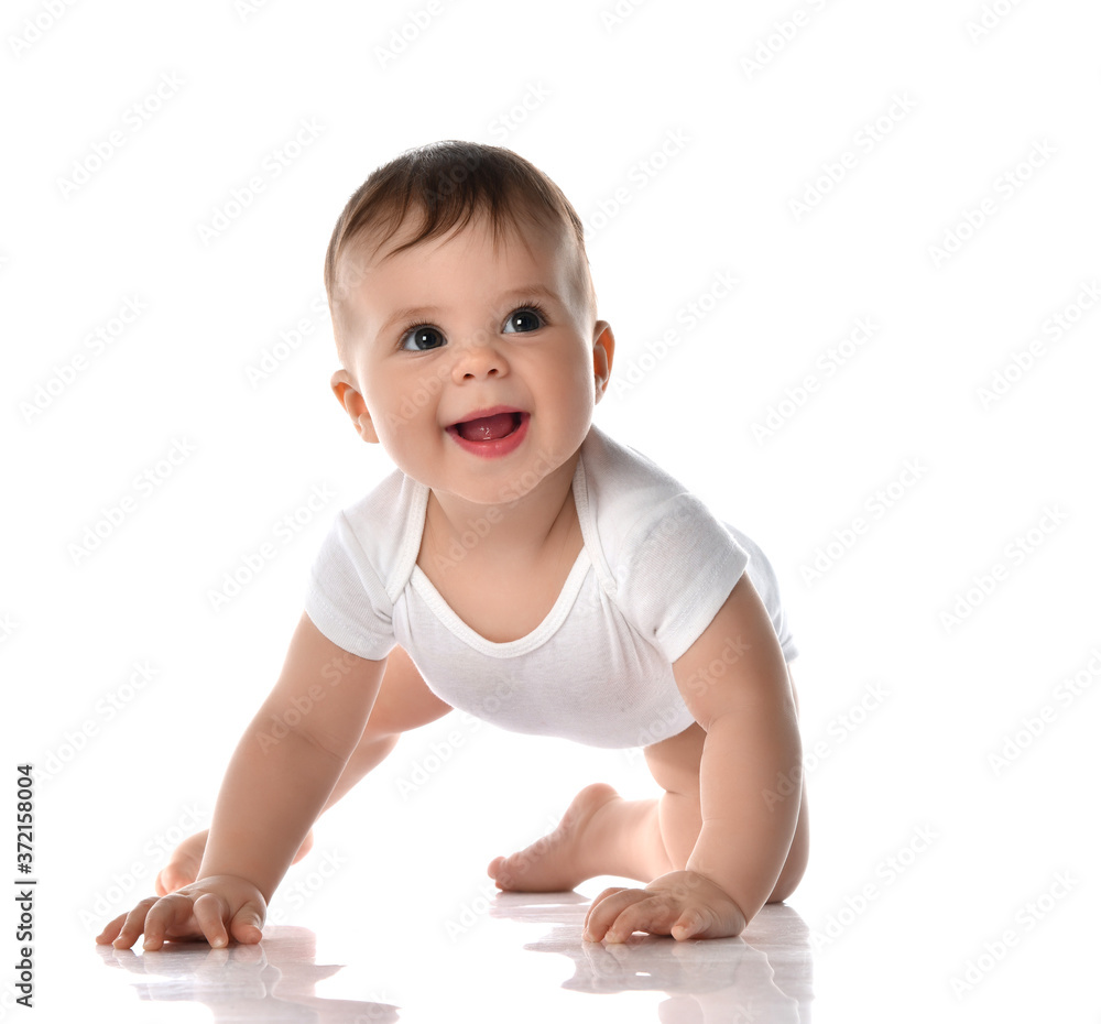 Laughing toddler baby in diaper and white bodysuit is crawling on floor and looking up at the corner trying to stand up Laughing toddler baby in diaper and white bodysuit is crawling on floor and looking up at the corner trying to stand up