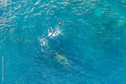Fototapeta Naklejka Na Ścianę i Meble -  Three people snorkling in the ocean in Amed, Bali, Indonesia
