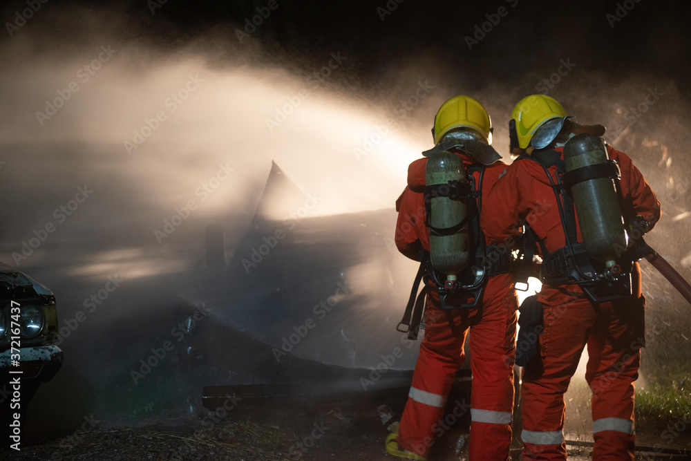 Fototapeta premium Firefighters spraying water to put out a brutal fire on the car.