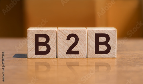 B2B business to business concept. Stack of wooden cubes on wooden floor.