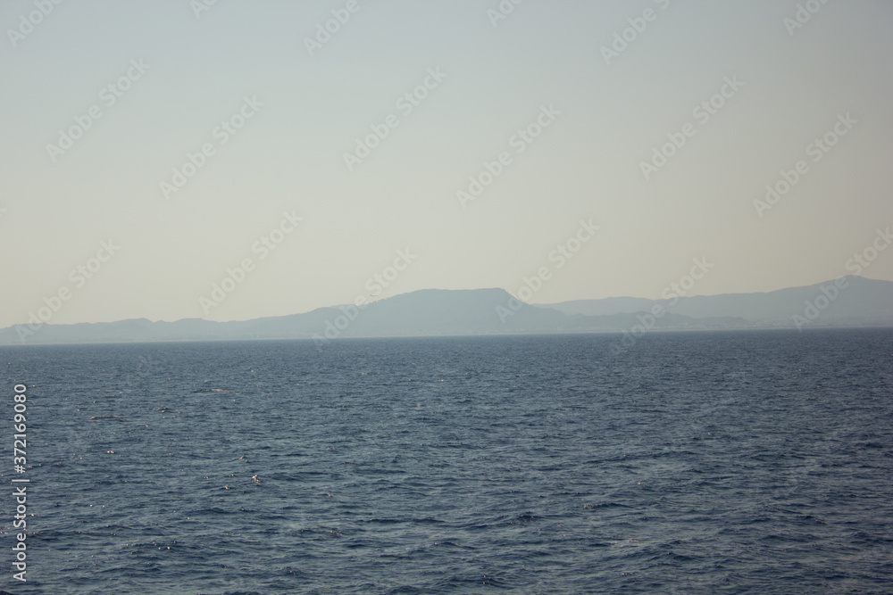 Obraz premium Greece. Rhodes island. Rest at the sea. Euro-trip. Sea water surface. Mountains in the background.