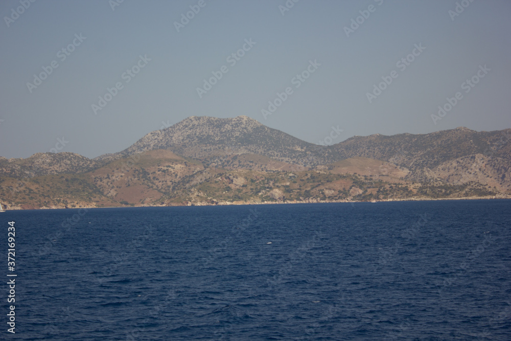 Greece. Rhodes island. Rest at the sea. Euro-trip. Sea water surface. Mountains in the background.