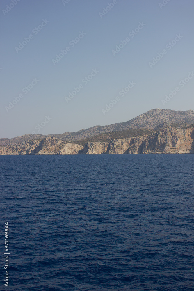 Greece. Rhodes island. Rest at the sea. Euro-trip. Sea water surface. Mountains in the background. Greece. Rhodes island. Rest at the sea. Euro-trip. Sea water surface. Mountains in the background.