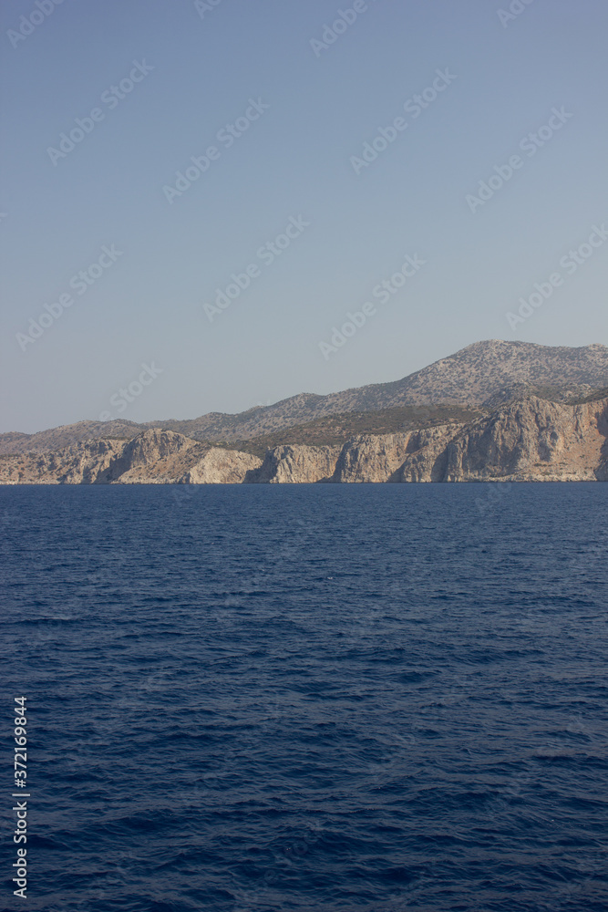 Greece. Rhodes island. Rest at the sea. Euro-trip. Sea water surface. Mountains in the background.