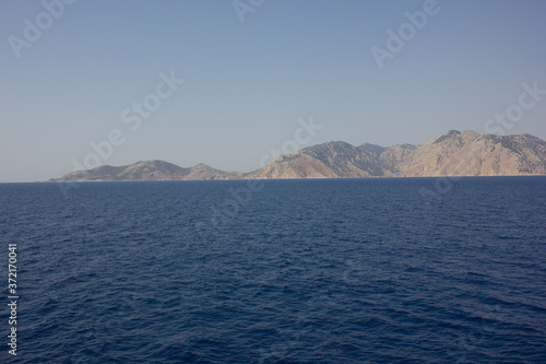 Greece. Rhodes island. Rest at the sea. Euro-trip. Sea water surface. Mountains in the background.