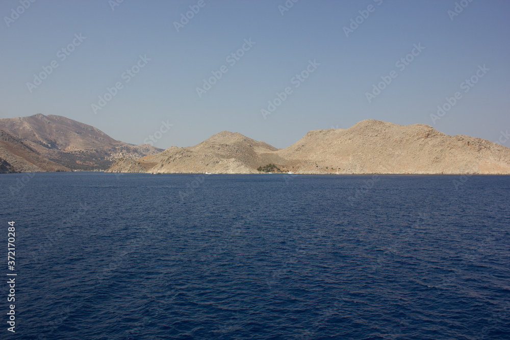 Greece. Rhodes island. Rest at the sea. Euro-trip. Sea water surface. Mountains in the background.