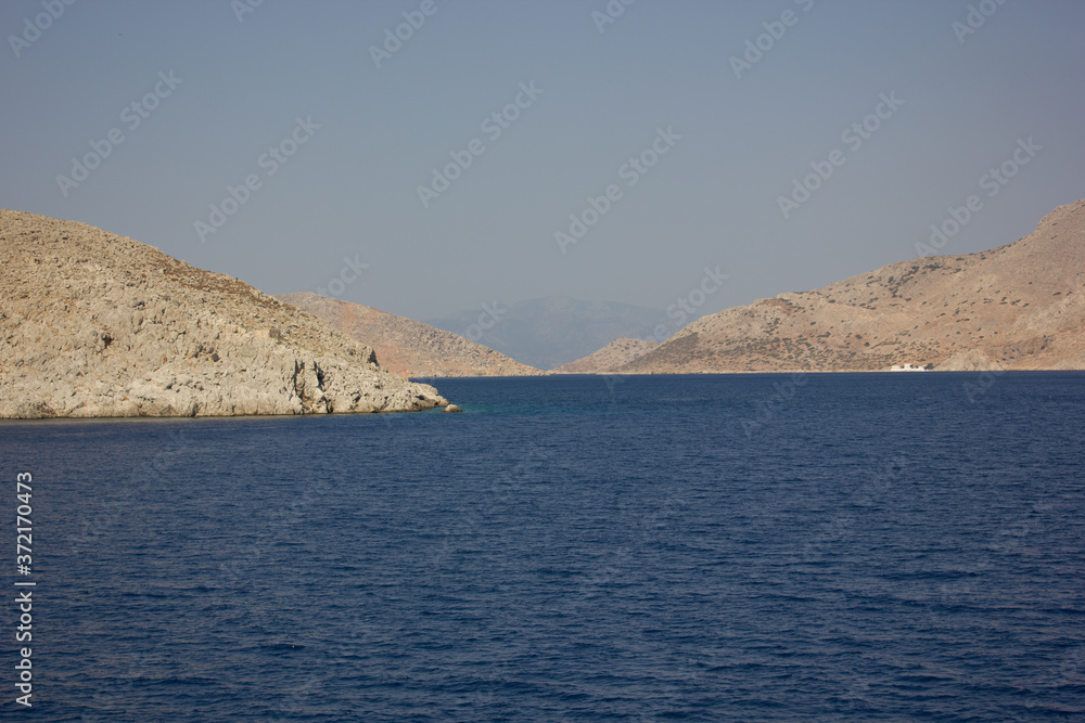 Greece. Rhodes island. Rest at the sea. Euro-trip. Sea water surface. Mountains in the background. Greece. Rhodes island. Rest at the sea. Euro-trip. Sea water surface. Mountains in the background.