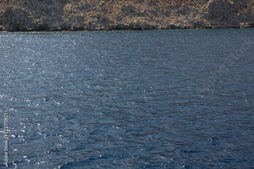 Greece. Rhodes island. Rest at the sea. Euro-trip. Sea water surface. Mountains in the background.
