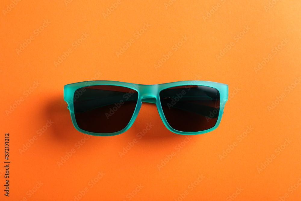 Stylish sunglasses on orange background, top view Stylish sunglasses on orange background, top view