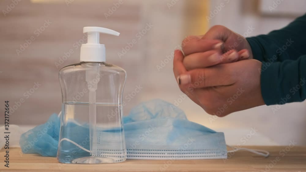 Hand sanitizer alcohol gel rub clean hands hygiene prevention of coronavirus virus outbreak. Travel surgical masks and hand sanitizer gel. Woman using bottle of antibacterial sanitiser soap. Hand sanitizer alcohol gel rub clean hands hygiene prevention of coronavirus virus outbreak. Travel surgical masks and hand sanitizer gel. Woman using bottle of antibacterial sanitiser soap.