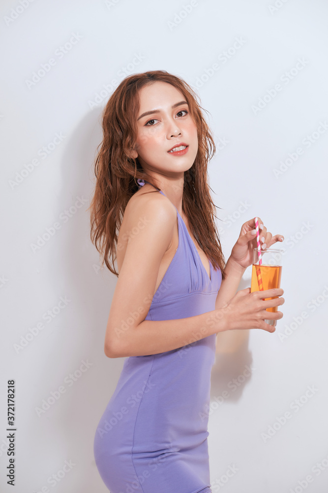 Young woman in purple dress drinking cocktail Young woman in purple dress drinking cocktail