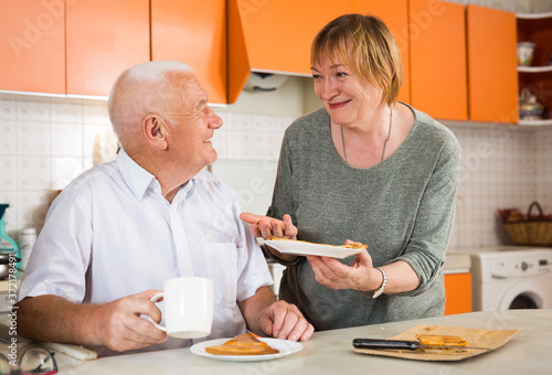 Portrait of happy senior couple having breakfast in kitchen