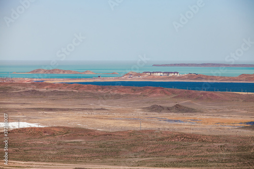 View on Balkhash lake coast. Panorama of desert and blue water. New houses for cement plant workers. Mynaral, Kazakhstan photo