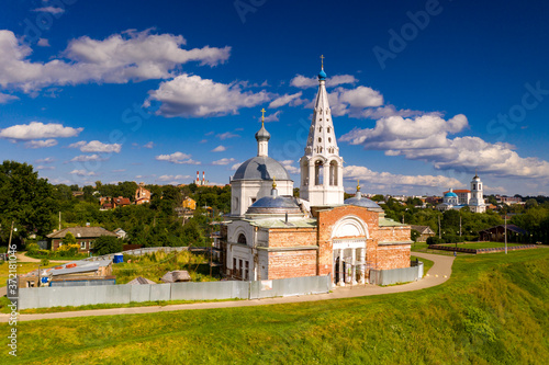 panoramic view of an old church in summer on a green hill against a cloudy sky background