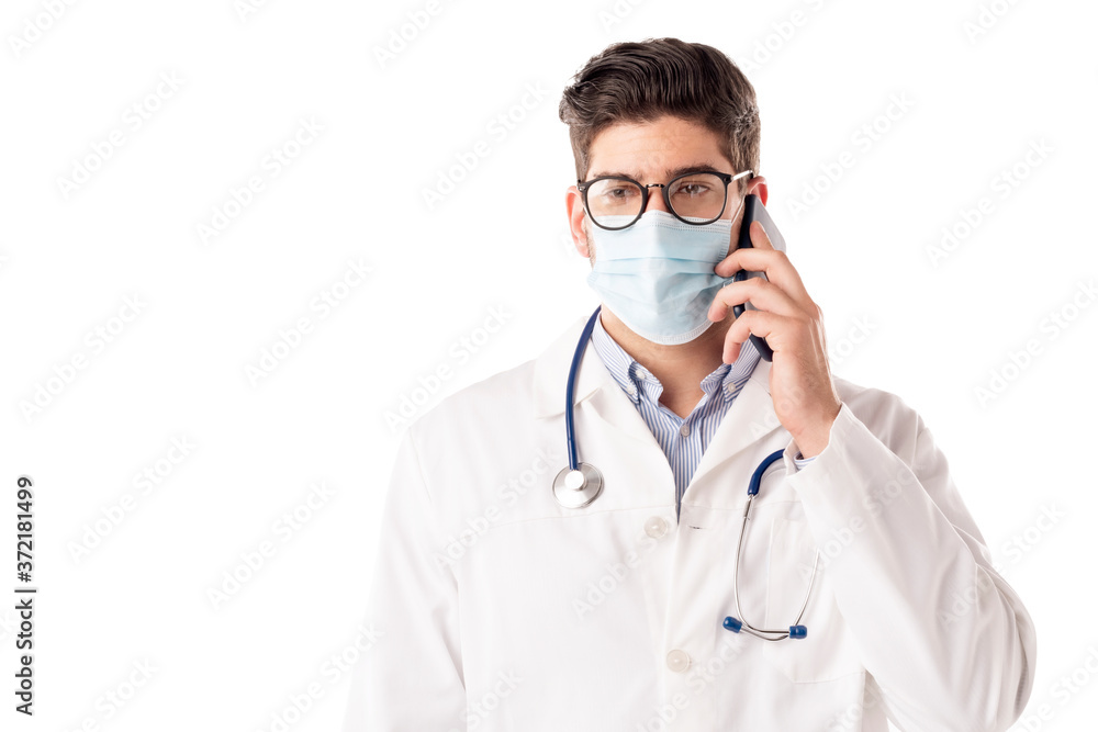 Studio portrait of male doctor talking with sombody on his mobile phone while standing at isolated white background Studio portrait of male doctor talking with sombody on his mobile phone while standing at isolated white background