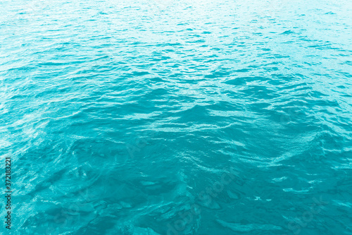 Aerial view of a crystal clear sea turquoise water texture. View from above Natural blue background. Turquoise water reflection. Blue ocean wave. Summer sea. Drone. Top view © Aleksei