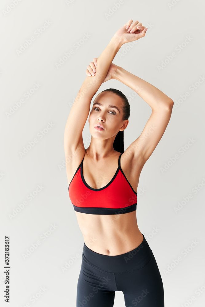 Young sporty female workout before fitness training session warming up and stretching her arms Young sporty female workout before fitness training session warming up and stretching her arms