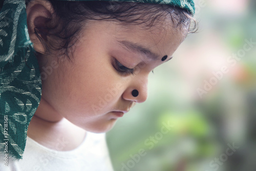 Cute Indian baby girl with traditional Indian dress with bindi on her forehead