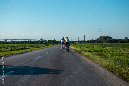 Three professional cyclists ride racing bikes through the fields where the beans are planted. The road is not loaded with cars for us either.