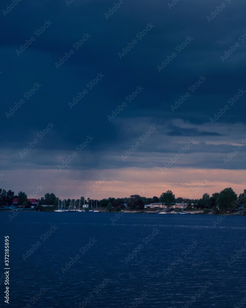 Fototapeta premium Sunset over the river, beautiful blue sky, stormy weather 