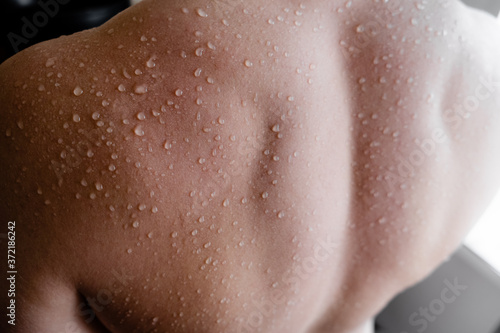 Muscular Man back with water drops. Fitnes and healt care concept top horizontal view copyspace