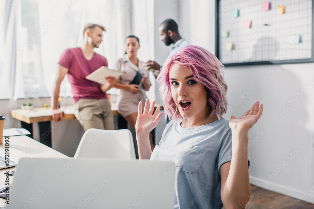 Selective focus of excited businesswoman looking at camera while working in white office Selective focus of excited businesswoman looking at camera while working in white office