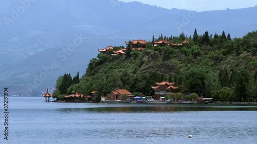 Chinese boats in Fuxian Lake in Yunnan Province China. Unique mountain lake in East Asia. Landscape on background of sky with gray clouds and fog. Silence and tranquility of nature. photo