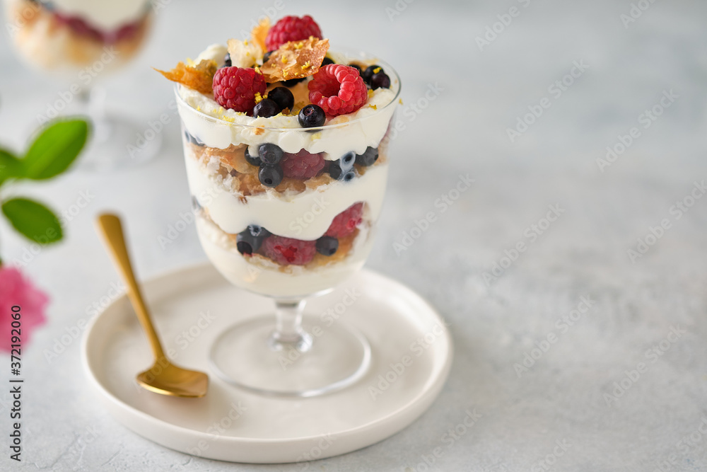 Dessert in a glass with raspberries and blueberries and cream. Dessert in a glass with raspberries and blueberries and cream.
