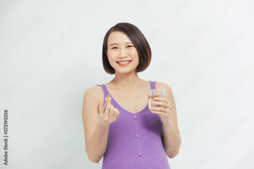 a woman takes vitamins during pregnancy. pregnant girl with a glass of water and a handful of drugs in her hand. a woman takes vitamins during pregnancy. pregnant girl with a glass of water and a handful of drugs in her hand.
