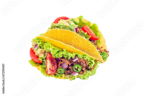 Two taco shells with lettuce, ground beef meat,  mashed avocado, tomato, red onion and jalapeno pepper, isolated on white, closeup